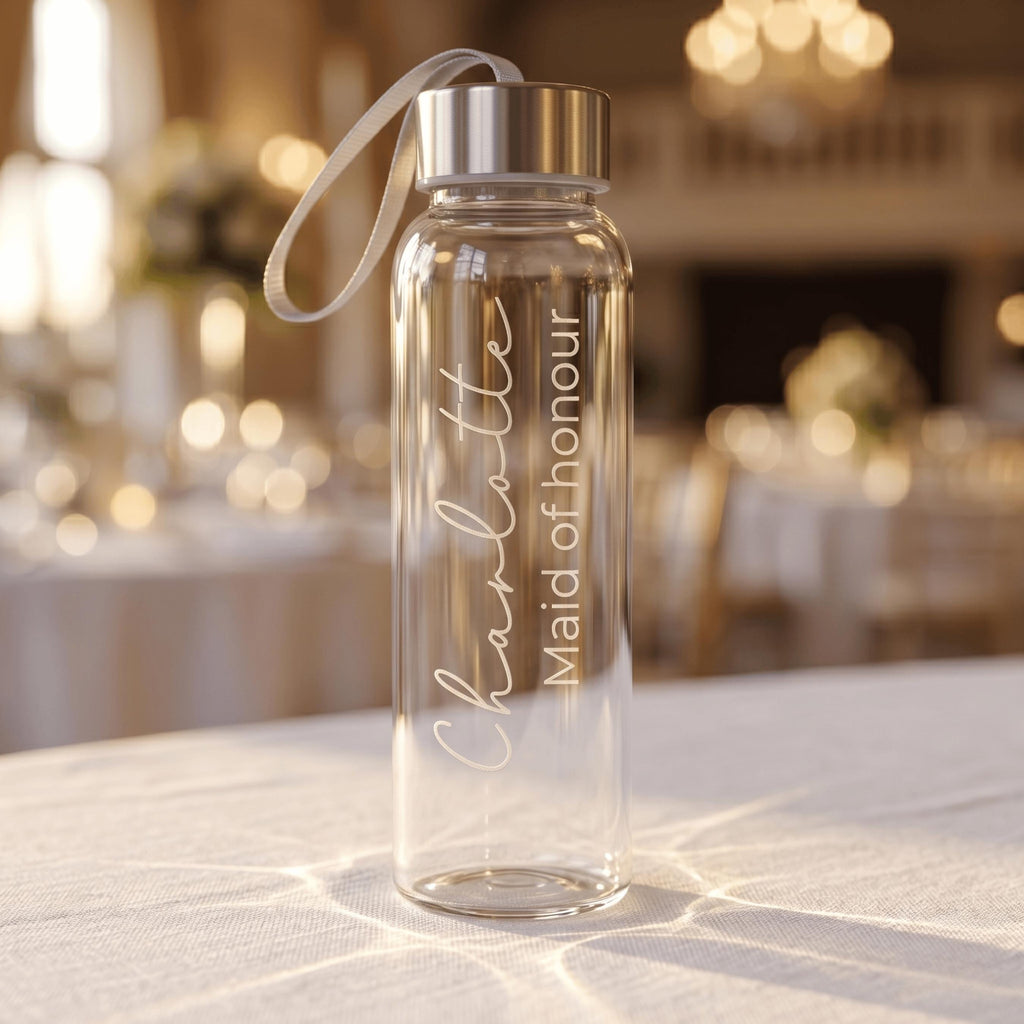 Custom engraved glass water bottle for a Maid of honour named Charlotte, featuring elegant vertical script on a clear bottle with a silver cap and carry strap.