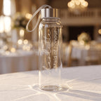 Custom engraved glass water bottle for a Maid of honour named Charlotte, featuring elegant vertical script on a clear bottle with a silver cap and carry strap.