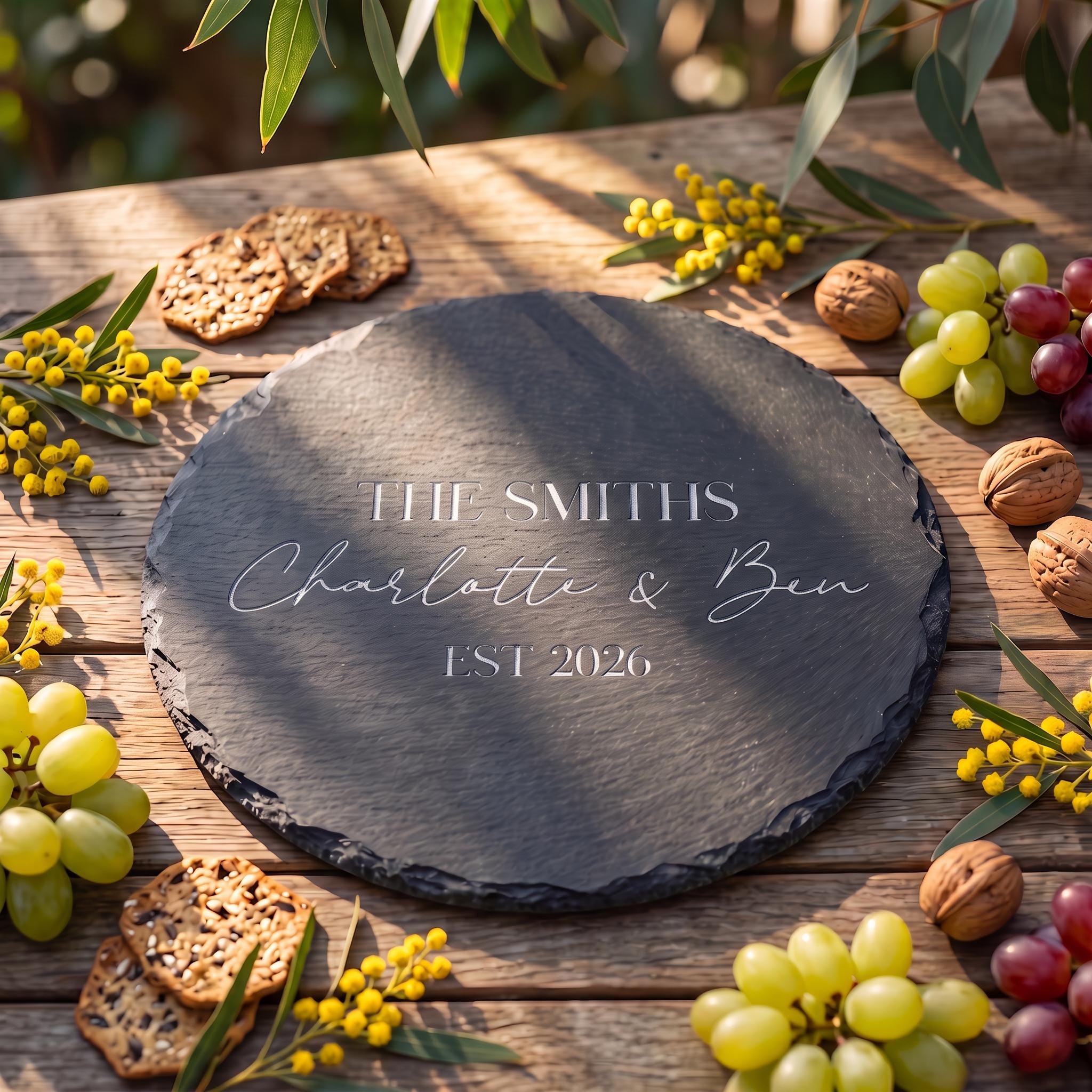 Bespoke engraved round slate board showing THE SMITHS Charlotte and Ben EST 2026 on natural dark stone.