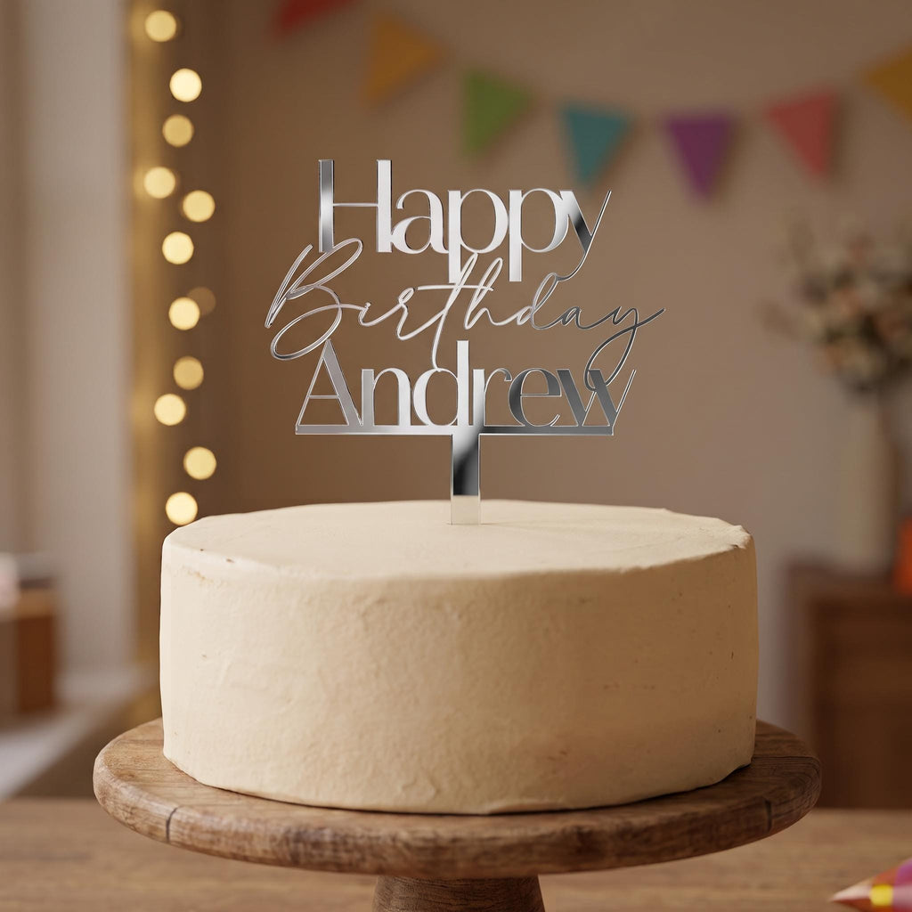 Custom Happy Birthday Andrew silver mirror acrylic cake topper placed on an iced cake.