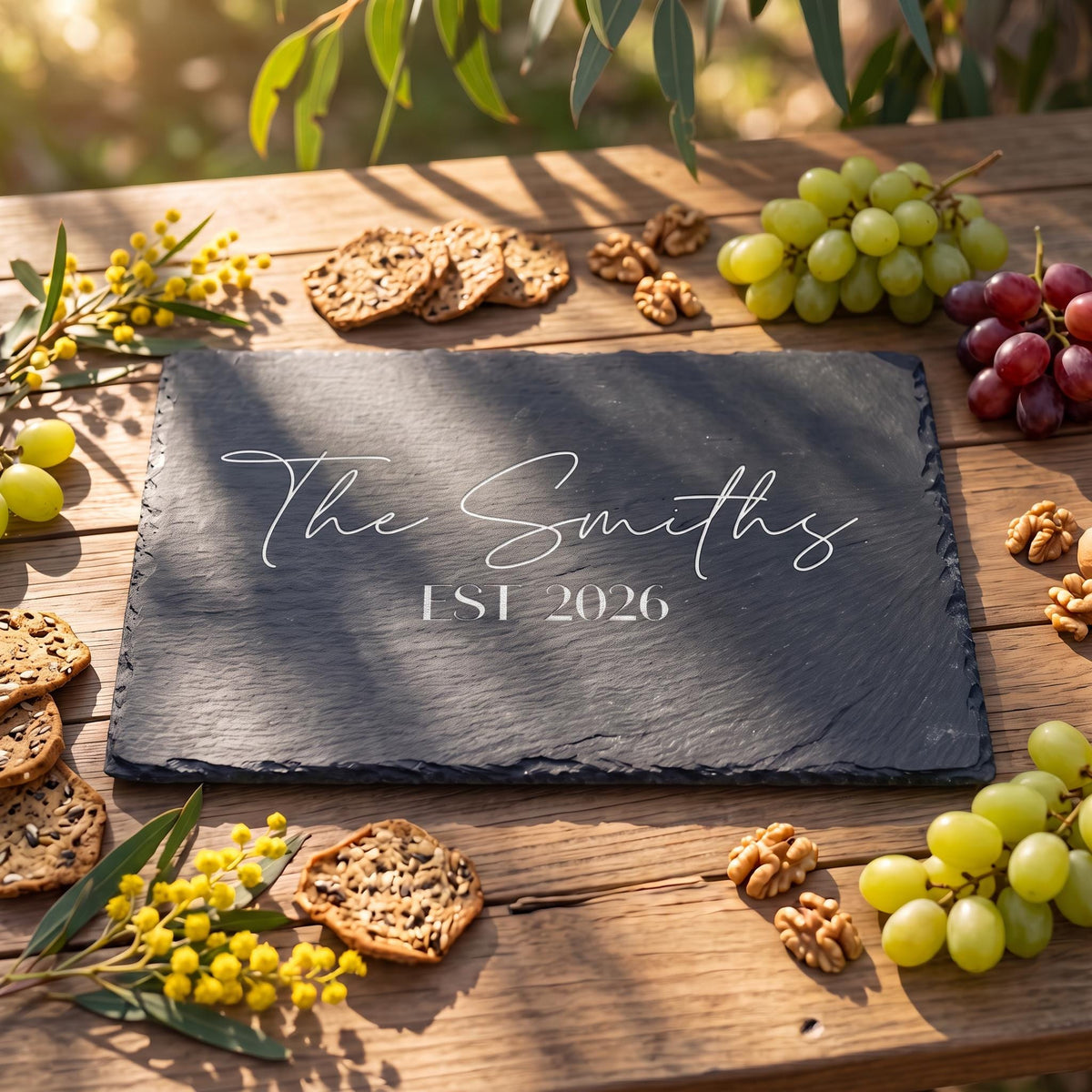 Custom slate cheese board engraved with The Smiths EST 2026 on rustic wood with native wattle.