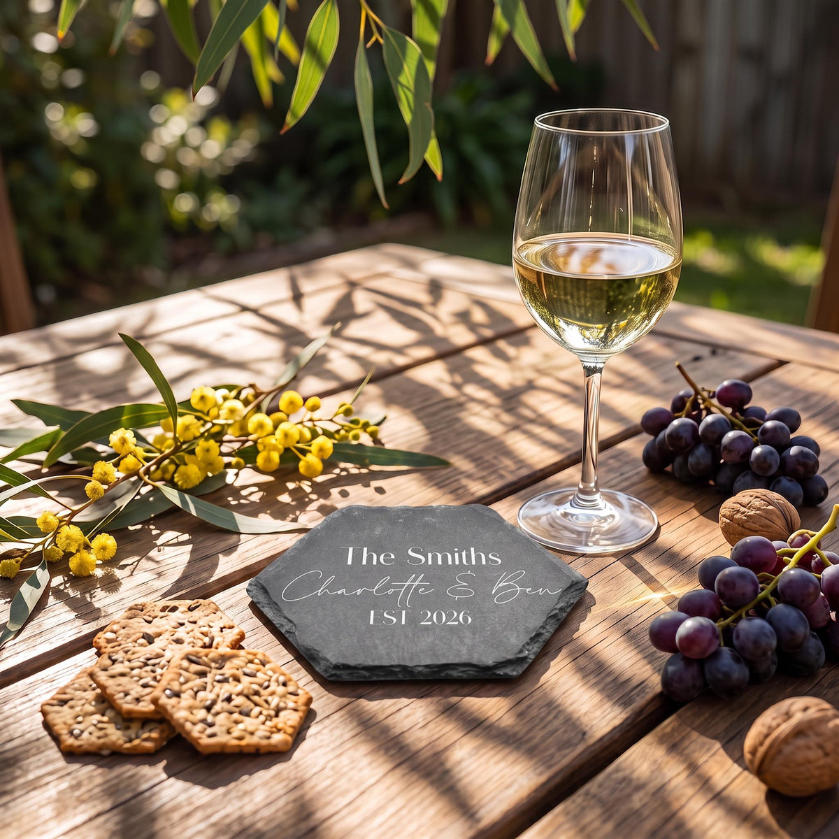 Bespoke engraved hexagon coaster showing The Smiths Charlotte and Ben EST 2026 on natural dark stone.