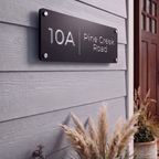 Custom laser cut address plaque featuring house number positioned top right mounted to an exterior brick wall.