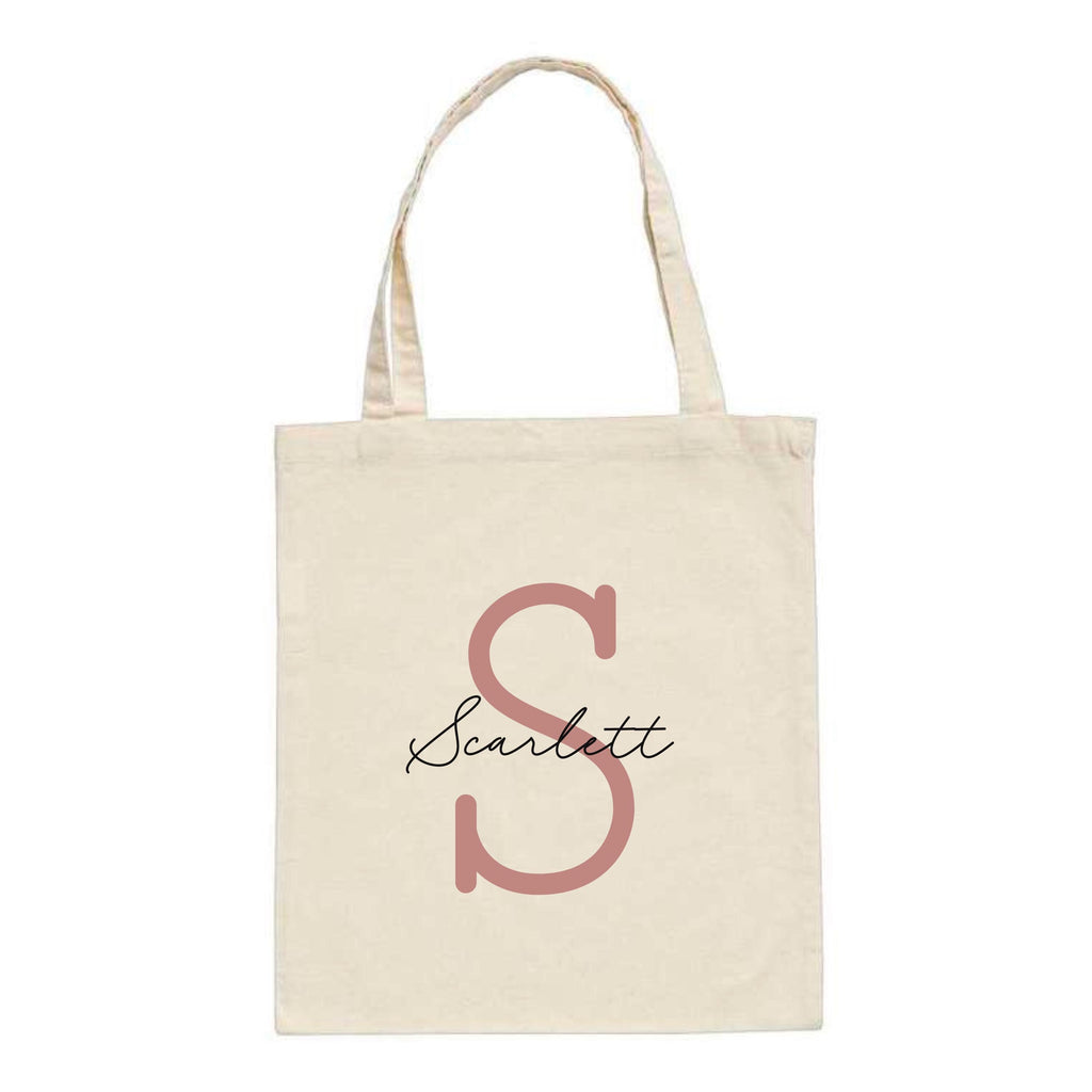 White personalised tote bag by Make It Personal Gift Co with monoline script and slab serif initials and name design.