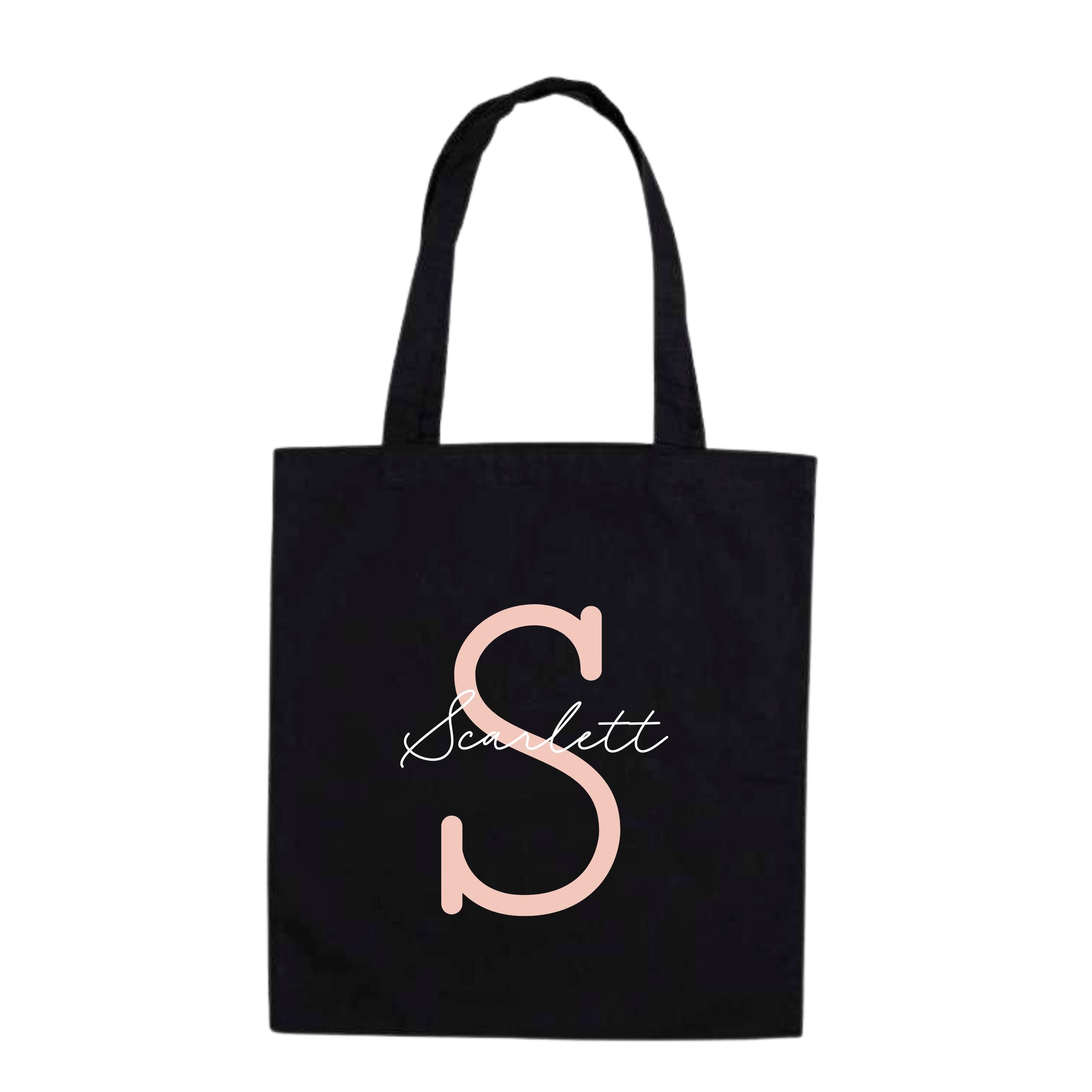 Personalised tote bag with monoline script and slab serif initials and name in black on natural canvas background.
