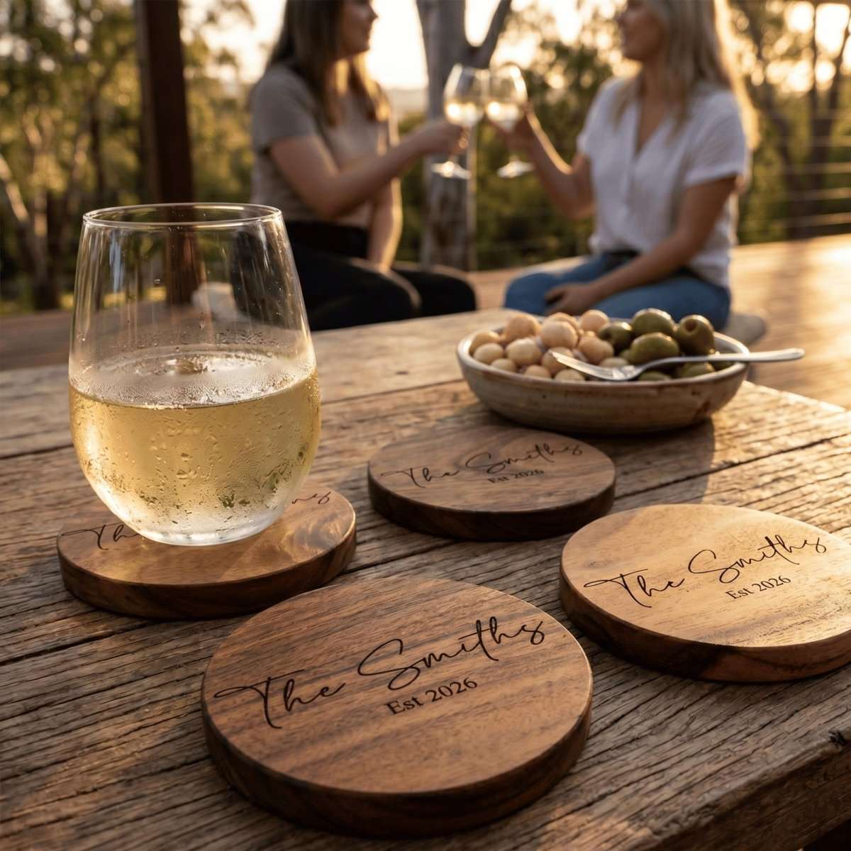 Personalised engraved acacia timber coasters styled on an Australian coffee table with drinks.