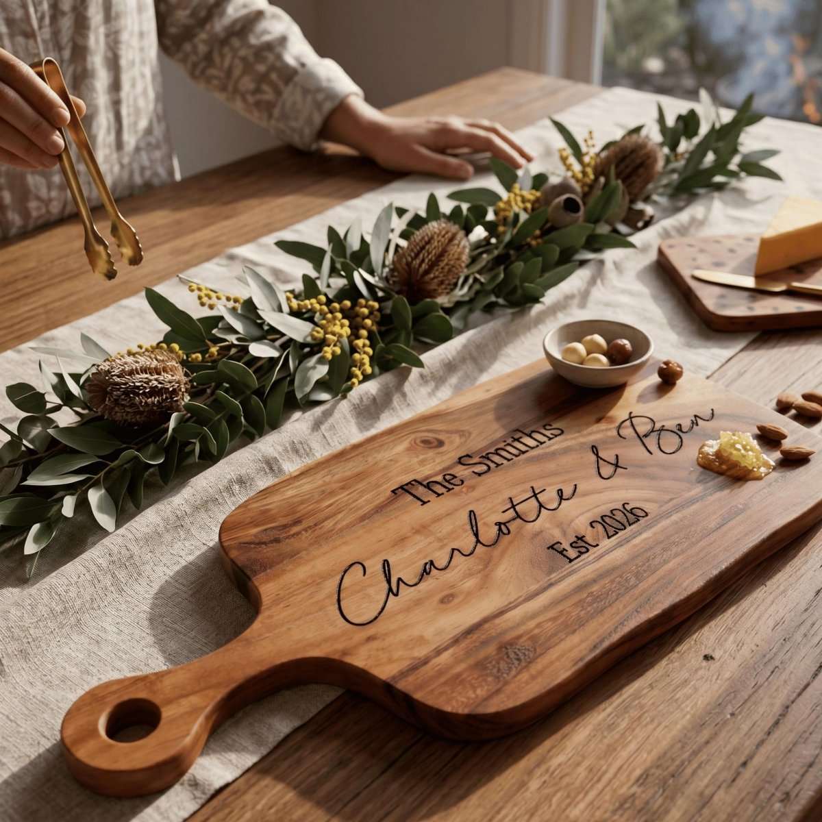 Personalised engraved 40cm by 20cm acacia timber serving board with handle styled on an Australian dining table with charcuterie.