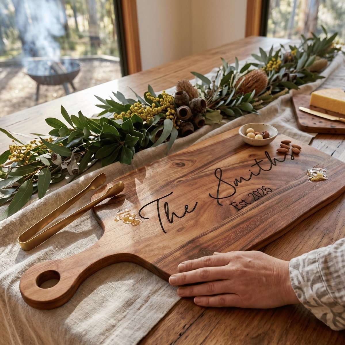 Personalised 40cm by 20cm acacia wood serving board with handle laser engraved in Timeless Classic typography on natural timber surface.