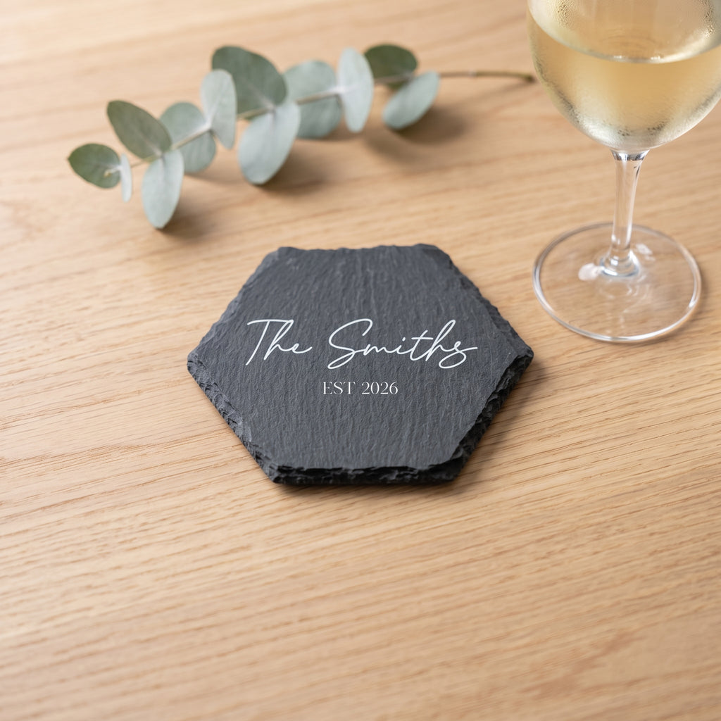 Personalised hexagon slate coaster laser engraved in Bespoke Heirloom script layout on natural dark grey stone surface.