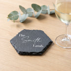 Personalised hexagon slate coaster laser engraved in Modern Elegance font layout on natural dark grey stone surface.