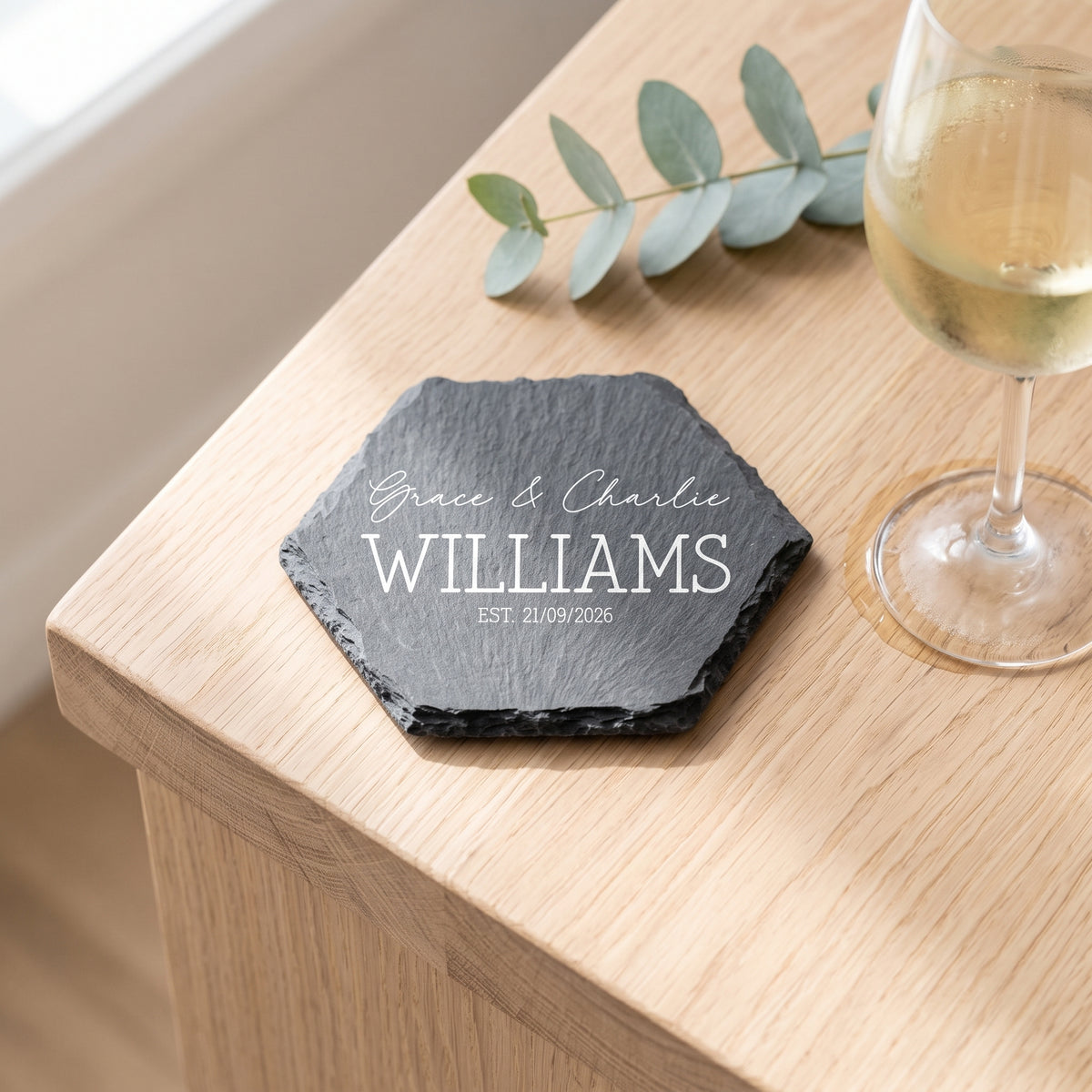 Personalised hexagon slate coaster laser engraved in Timeless Classic font layout on natural dark grey stone surface.