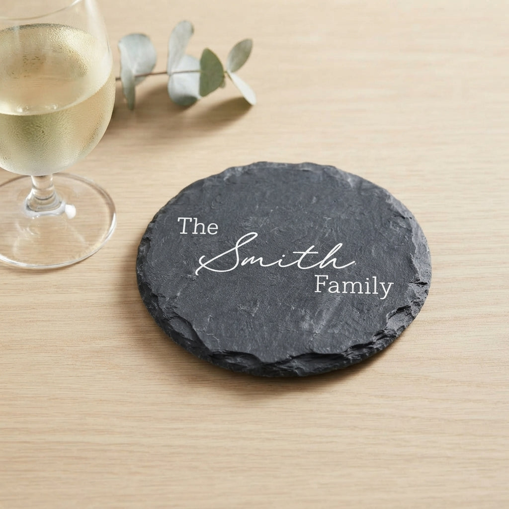 Personalised engraved round slate coaster styled with a drink glass on a timber table in Australia.