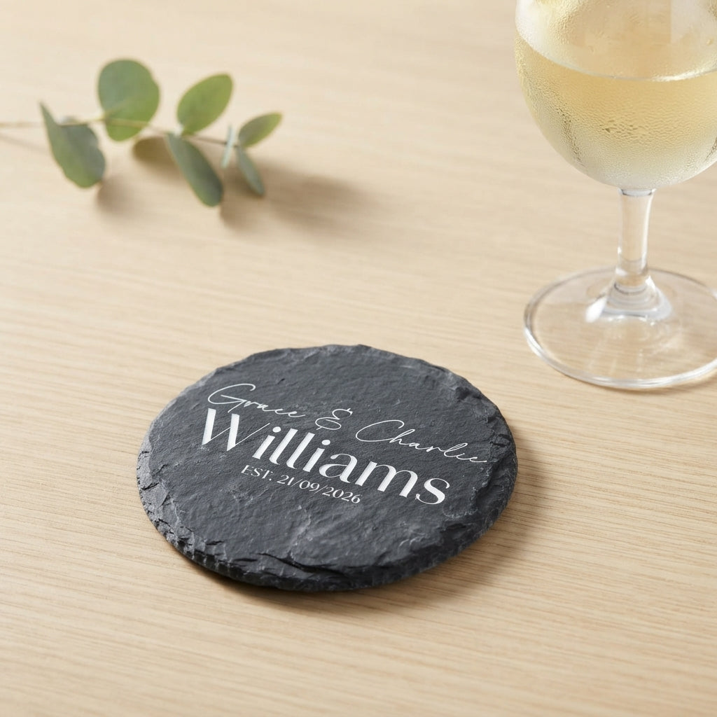 Personalised engraved round slate coaster styled with a drink glass on a timber table in Australia.