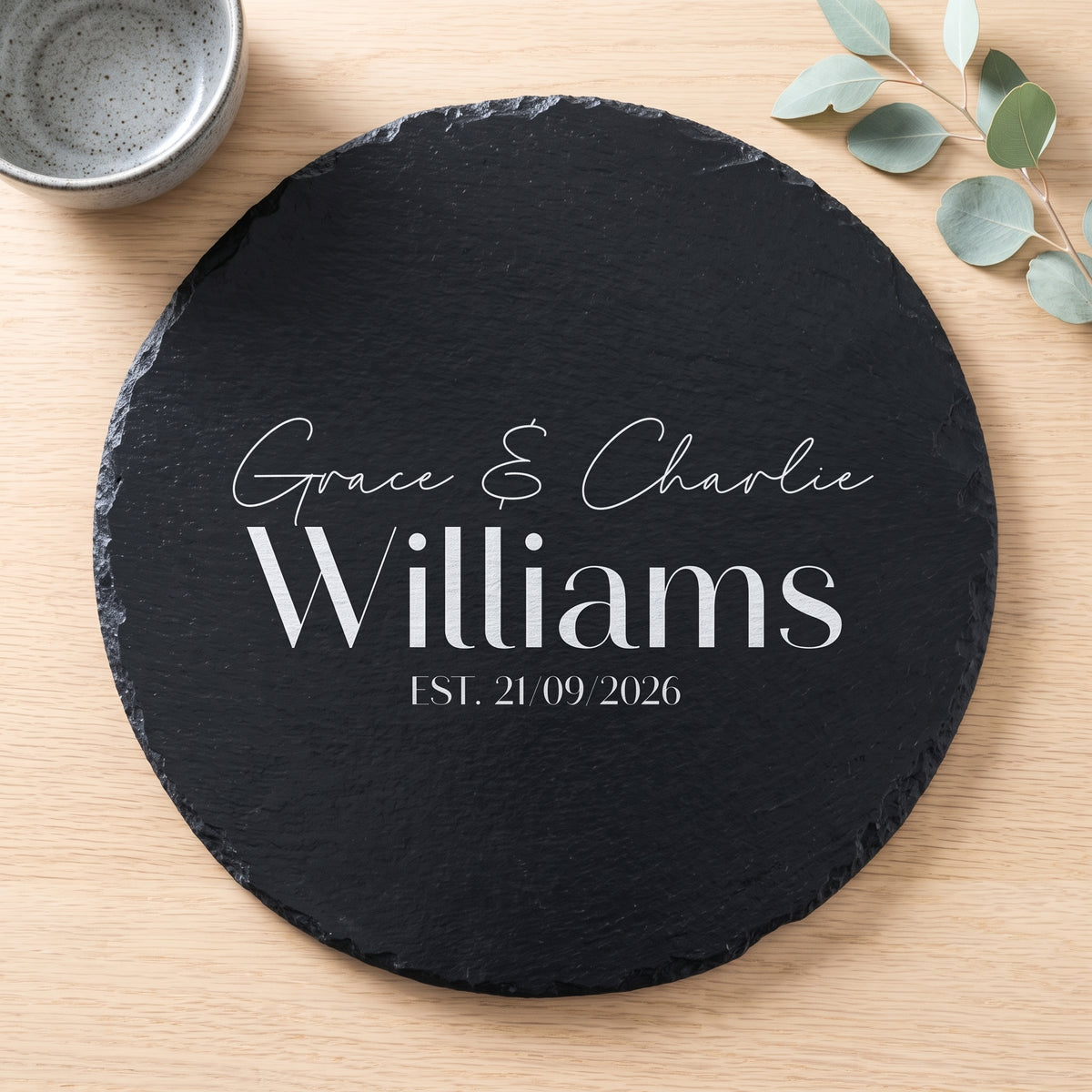 Personalised engraved round slate platter styled with artisanal cheeses and fruit on a wooden table in Australia.