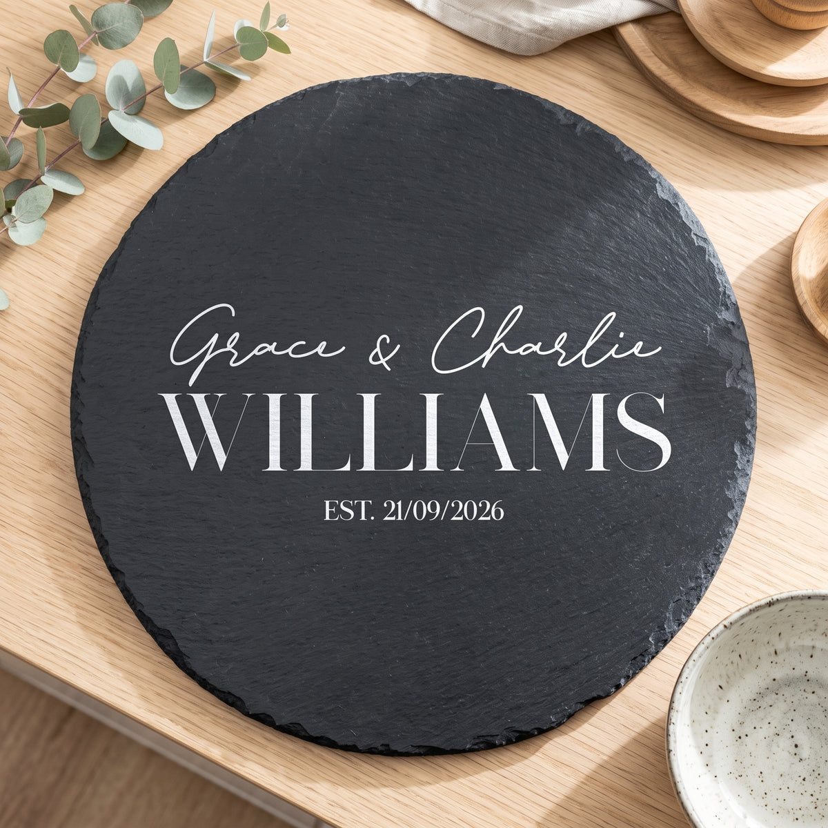 Personalised engraved 30cm round slate platter styled with artisanal cheeses and fruit on a table in Australia.