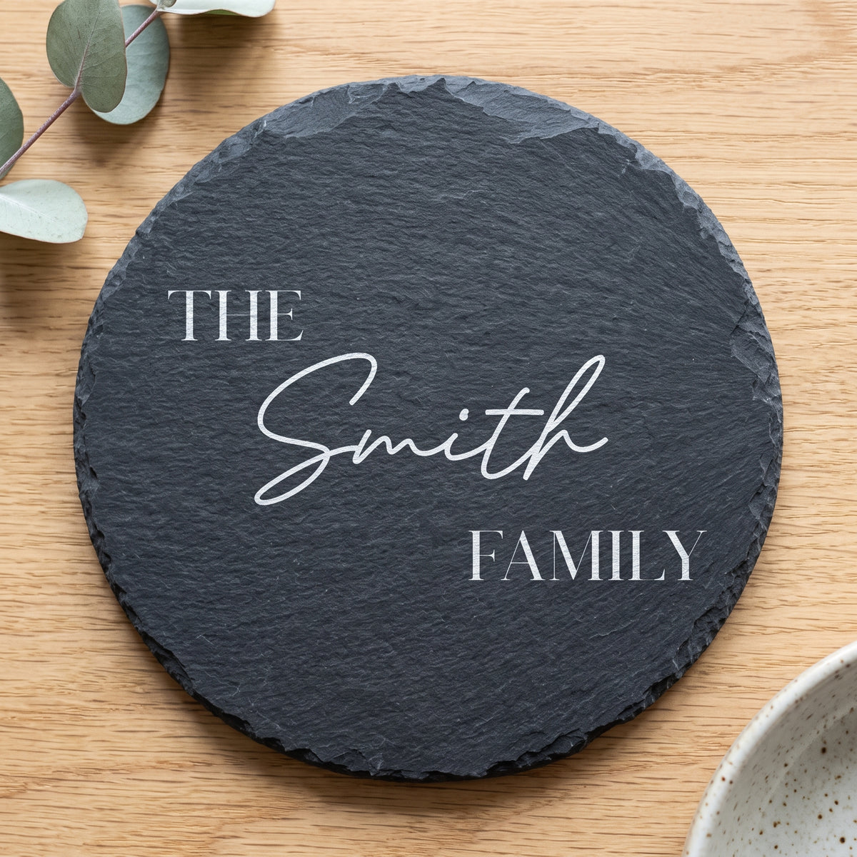 Personalised 30cm round slate platter laser engraved in Bespoke Heirloom script layout on dark stone surface.