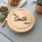 Personalised engraved round swivel cheese board styled with cheeses and fruits on a wooden dining table in Australia.