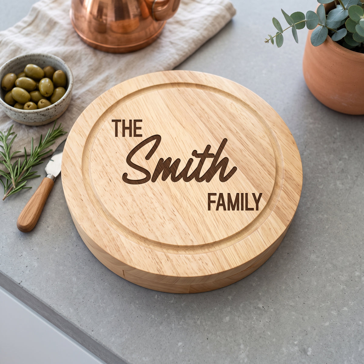 Personalised engraved round swivel cheese board styled with cheeses and fruits on a wooden dining table in Australia.