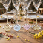 A personalised hooped wine glass charm featuring a custom laser cut guest name in gold mirror acrylic clipped onto a gold metal stem hoop, handcrafted by Make It Personal Gift Co in Australia.