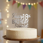 Personalised silver mirror acrylic cake topper showing Happy 18th Birthday Scarlet on a white iced cake.