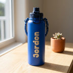Close up side view of the royal blue insulated drink bottle highlighting the permanent laser engraved steel lettering and leak proof sports cap.